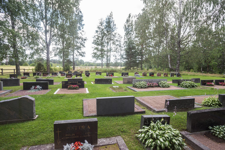 Yleiskuva hautausmaalta, hautakiviä ja nurmialuetta.