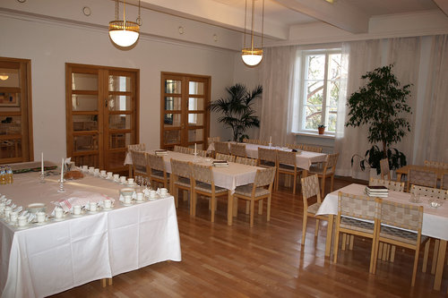 Helilän seurakuntakeskuksen sali, jossa pöytiä, tuolia ja kahvikattaus.