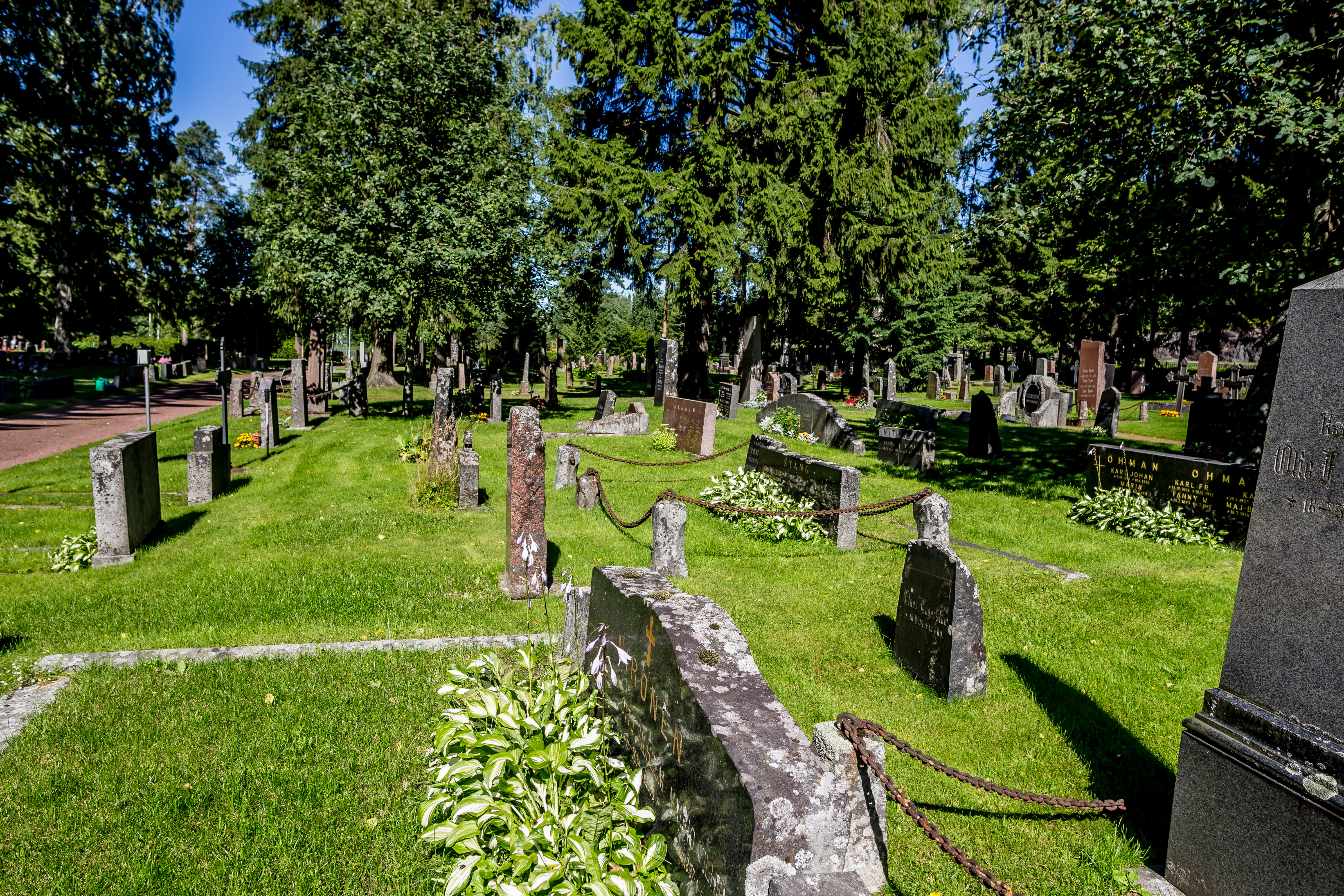 Yleiskuva hautausmaalta, hautakiviä ja nurmialuetta.