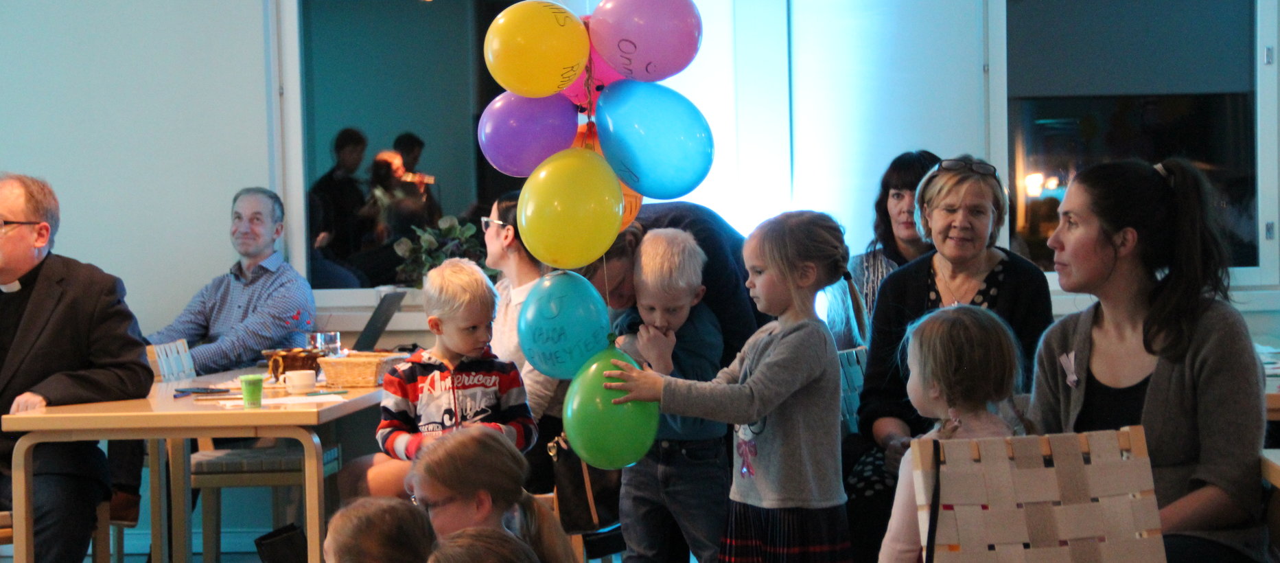 Kuvassa lapsia ja aikuisia Langinkosken kirkon Toivonsalissa. Lapsilla käsissään ilmapalloja.