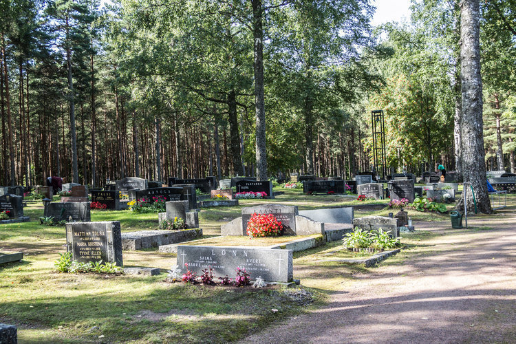 Yleiskuva hautausmaalta, hautakiviä, puita ja nurmialuetta.
