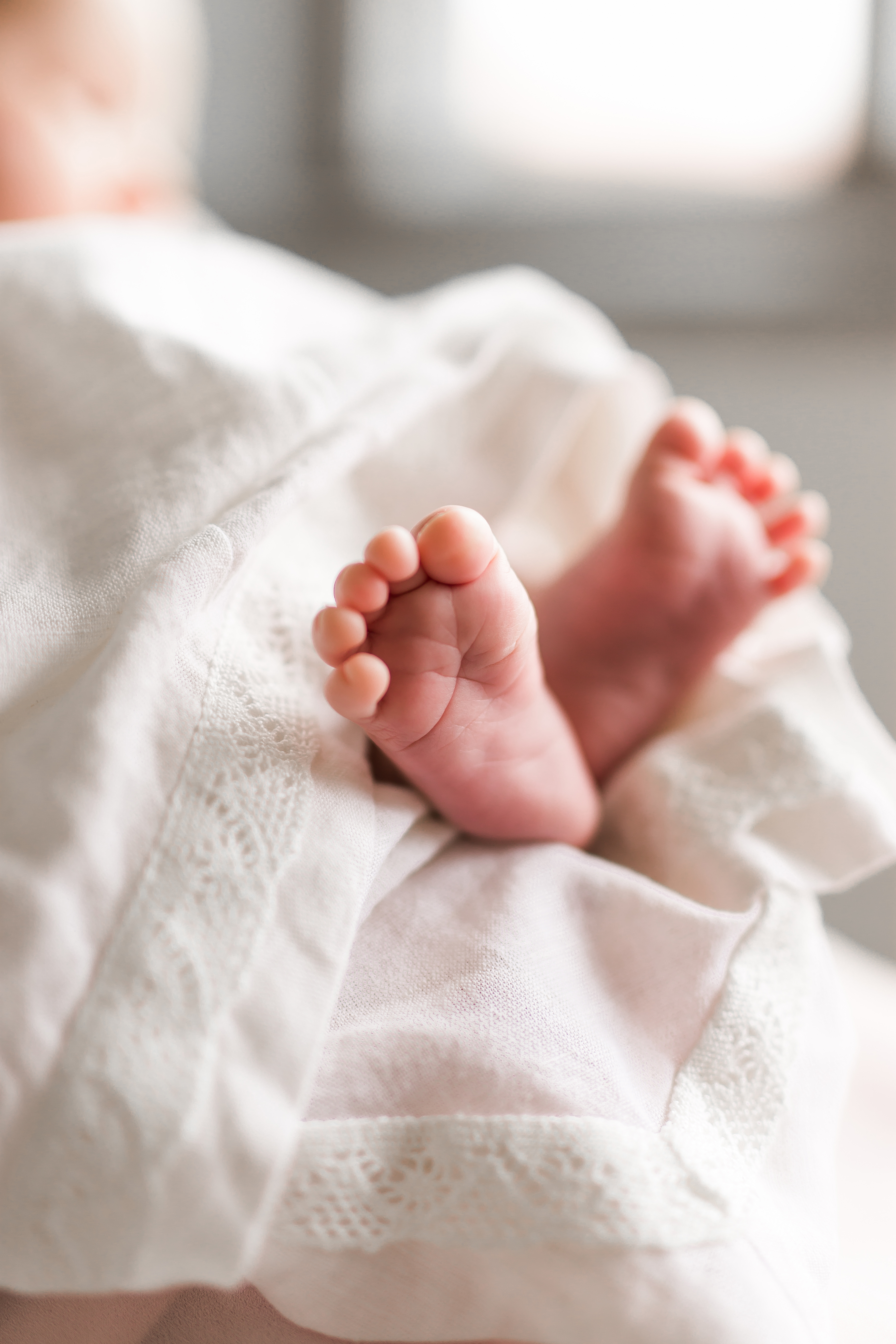 Vauvan jalat näkyvät vaalean kankaan alta.
