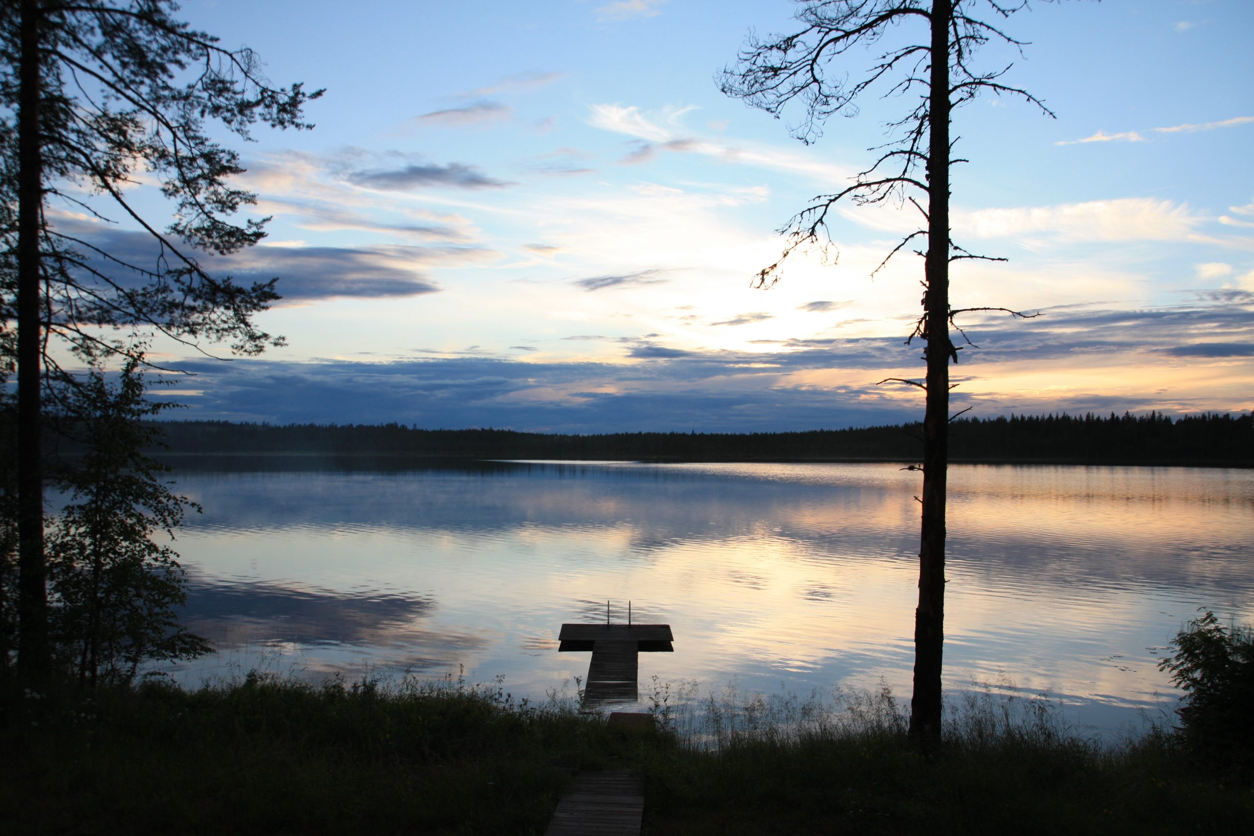 Järvimaisema, aurinko on juuri laskenut.